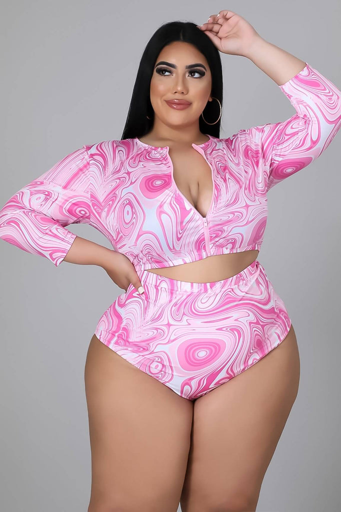 Plus size model wearing a pink and white long sleeve and high waisted bikini set